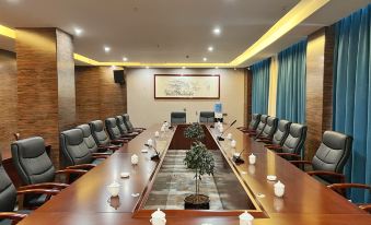 a large conference room with a long wooden table and several chairs arranged around it at Gushi Oriental Earl Hotel (Yucheng Avenue Genqin Culture Park)