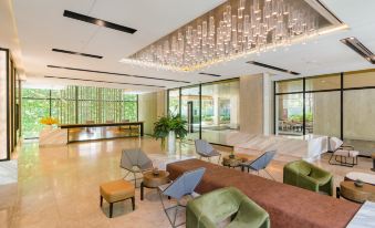 a modern office space with large windows , green walls , and a reception area filled with comfortable seating at Hotel Amber Pattaya