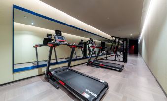 There is a spacious room with an indoor treadmill and other exercise equipment available in a home that is currently for sale at Grade Hotel Shenzhen sea world