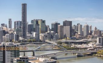 a cityscape with a river and a bridge in the foreground , and tall buildings in the background at The Milton Brisbane