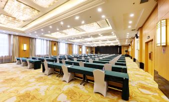 A spacious room with rows of long tables arranged for an event at the hotel at Yan An Hotel