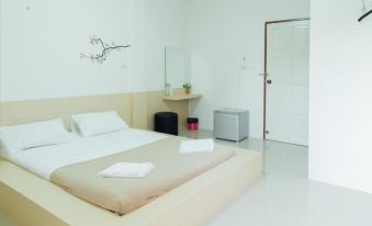 a clean and minimalist bedroom with a bed , a desk , and a mirror on the wall at Cheaper Room