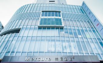 In a Japanese city, there is a large building with a front view and an entrance at Mercure Guangzhou Beijing Road Pedestrian Street Hotel