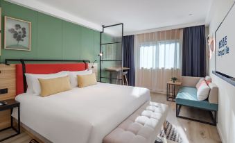 A spacious bedroom with a large bed and a table in the center, accompanied by an open area at Campanile Hotel (Shanghai The Bund)