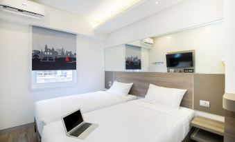 a hotel room with two beds , a laptop on one of the beds , and a tv in the corner at Red Planet Manila Bay
