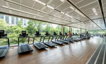A well-equipped gym with large windows and floor-to-ceiling glass is available for exercise at Inspirock Hotel