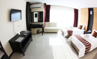 a clean and modern hotel room with a comfortable bed , a tv , and a desk at White Inn Nongkhai Hotel