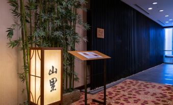 The room is decorated with bamboo, wall signs, and an oriental-style lamp at Okura Garden Hotel Shanghai