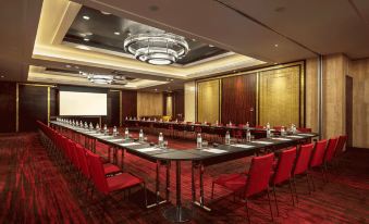 a large conference room with multiple rows of chairs arranged in a semicircle , and a projector on the wall at Grand Hyatt Manila