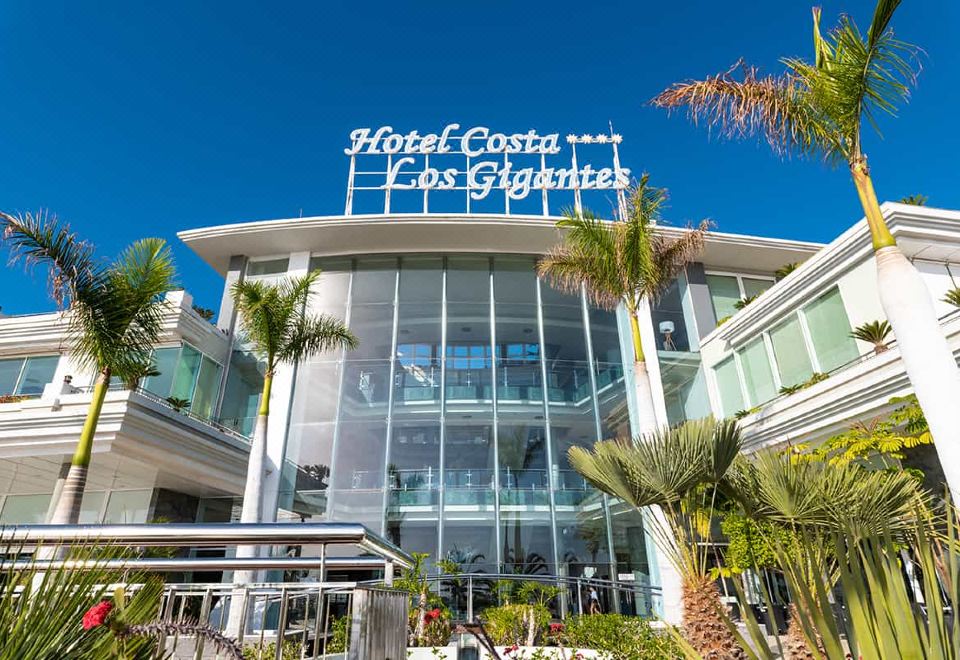"a large hotel building with a glass facade and the name "" hotel costa "" displayed on it" at Landmar Costa Los Gigantes