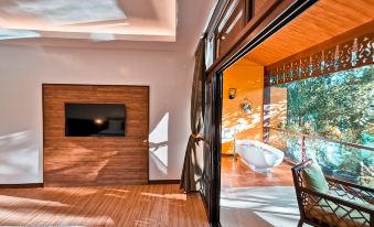 a modern living room with a large window and sliding glass door leading to a balcony at Loboc River Resort