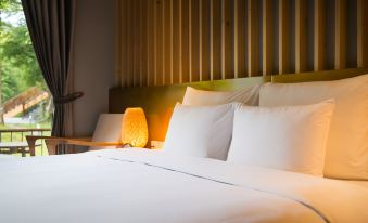 a large bed with white sheets and pillows is in a room with a wooden headboard at Alba Wellness Resort by Fusion