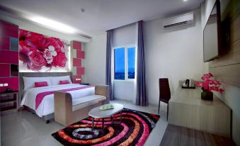 a hotel room with a comfortable bed , a television , and a rug on the floor at favehotel Langko Mataram - Lombok
