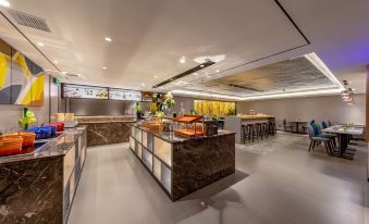 The restaurant features an open concept layout with tables, chairs, and a counter, leading to a spacious dining area offering a range of seating choices at Homeinn Selected (Foshan Zumiao Metro Station)