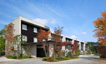 a modern apartment building with a white exterior and black accents , surrounded by trees and plants at Fairfield by Marriott Tochigi Utsunomiya