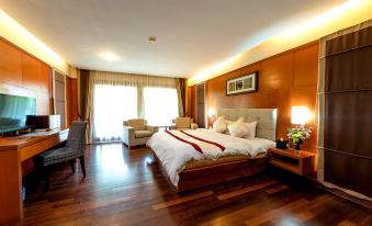 a large bed with a wooden headboard is in the center of a room with hardwood floors at Duyong Marina & Resort