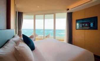 a luxurious hotel room with a large bed , white linens , and a view of the ocean at Seashells Phu Quoc Hotel & Spa