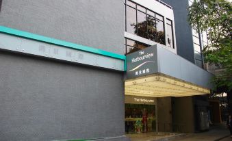 There is an entrance to a building with an oriental sign above it, as well as another large white door at The Harbourview-Chinese YMCA of Hong Kong