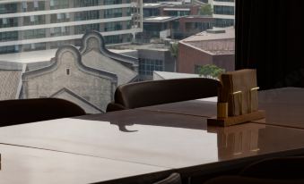 A room with large windows and chairs around a table in front serves as an office at Atour Hotel Shunde Happy Coast Foshan