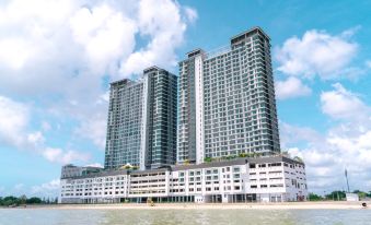 a tall building with multiple floors and balconies is situated on the waterfront near the beach at Swiss-Belhotel Kuantan