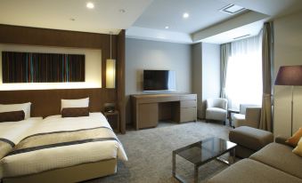 a hotel room with a king - sized bed , a couch , a television , and a dining table at Noboribetsu Grand Hotel