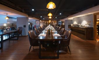 An upscale restaurant features a long table and chairs in the middle room, adorned with wood paneling at James Joyce Coffetel Hotel (Guangzhou Beijing Road Metro Station Pedestrian Street)