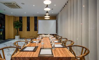 There is a spacious conference room equipped with a long table and chairs suitable for meetings and other business events at Shanghai JOYFUL YARD Hotel (Shanghai Pudong Airport Store)