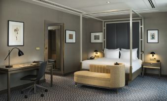 a hotel room with a king - sized bed , a couch , and a dining table in the corner at Hilton Vienna Plaza