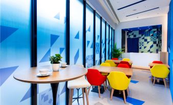 The blue and white room is furnished with a small table and chairs at Holiday Inn Express Macau City Centre