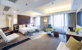 A spacious and elegantly furnished room with a bed, couch, and chair in the center at Empire Hotel Hong Kong－Wan Chai