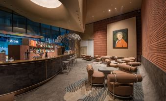 The lobby or restaurant features tables and chairs in the front, with a bar located on one side at Grade Hotel Shenzhen sea world