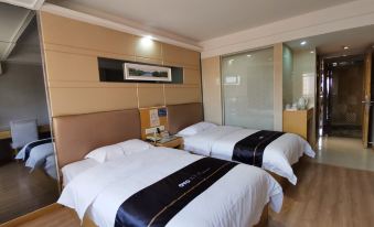 The large bedroom features double beds with a black headboard and a king-size bed at Yile Hotel