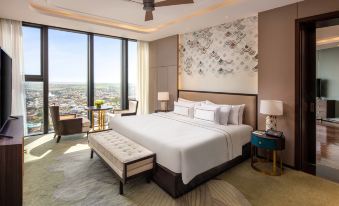 a luxurious hotel room with a large bed , two nightstands , and a view of the city at Melia Vinpearl Hue