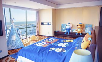 a spacious bedroom with large windows and toys scattered on the bedspread at Four Points by Sheraton Qingdao, West Coast