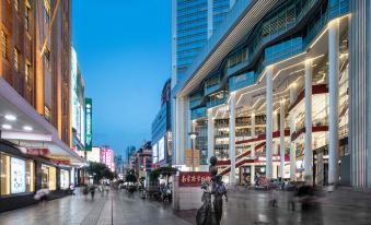 urban road at night, where pedestrians are walking and cycling on the sidewalk at Crowne Plaza Shanghai Nanjing Road