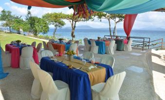 a dining area with tables and chairs set up for a formal event , possibly a wedding reception at Almont Beach Resort