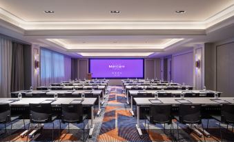 A spacious room is set up with tables and chairs for events or conferences at Mercure Shanghai Hongqiao SOHO