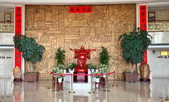 a large , ornate room with a wooden altar in the center and several potted plants on either side at Gushi Oriental Earl Hotel (Yucheng Avenue Genqin Culture Park)