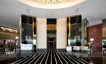The lobby and entrance of this modern hotel feature an ornate ceiling in a large building at Golden Pear Hotel