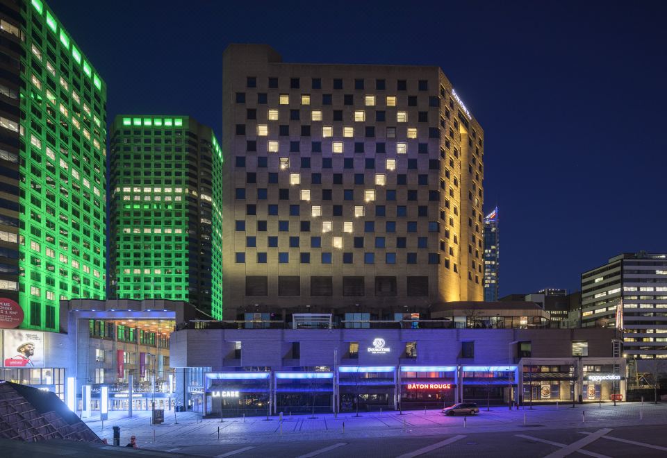 a tall building with a heart - shaped light display on its side , surrounded by other buildings and lights at Doubletree by Hilton Montreal