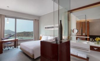 A modern bedroom with large windows and a balcony provides a view of the other rooms at Novotel Citygate Hong Kong