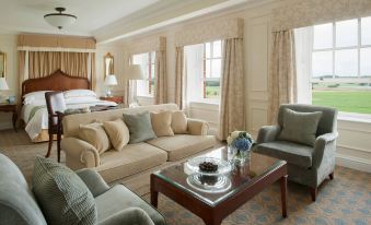 a luxurious hotel room with two couches , one on the left and one on the right , as well as a dining table and chairs at Four Seasons Hotel Hampshire