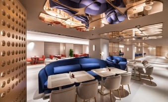 In the center of the restaurant, tables and chairs are illuminated by overhead lighting at Crystal Orange Hotel（Shanghai Hongqiao Gubei Road）
