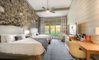 a room with two beds , a television , and a sliding glass door leading to an outdoor patio at Lodge of Four Seasons Golf Resort, Marina & Spa