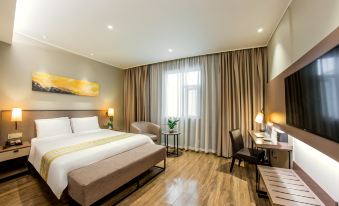 The bedroom is equipped with a double bed, a large table in the center, and chairs on the side at Home Inn Plus (Shanghai Bund Jinling East Road store)