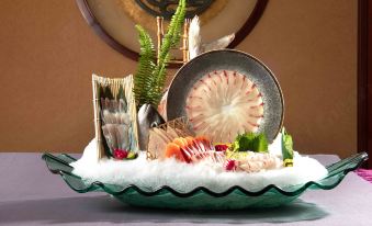 a plate of sushi with a variety of fish , seaweed , and other items on a table at Golden Hotel