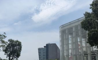 A large building with a clear view of the blue sky in front at Mercure Hotel (Shanghai Hongqiao Railway Station)