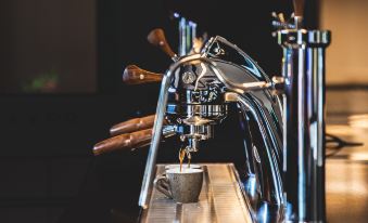 A close-up view of a tap and coffee beans in an espresso machine at Page148, Page Hotels