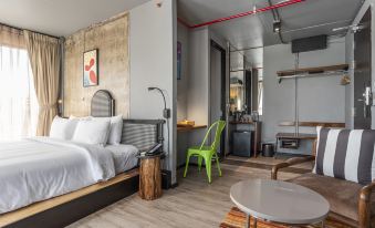 The middle room contains a bedroom with a bed, table, and chairs in an open concept layout at MeStyle Museum Hotel