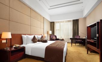 a large bed with a brown headboard and white sheets is in the middle of a room at Golden Hotel